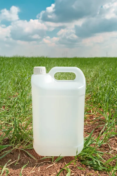 Kontainer berisi pestisida kosong yang diejek di padang rumput gandum — Stok Foto