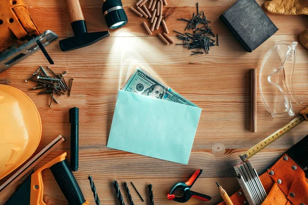 Dinero en sobres en el escritorio del taller de carpintería —  Fotos de Stock