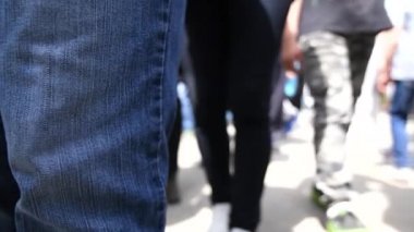 Yavaş çekimde sokak kalabalığının düşük açı görünümü, kayıp çocuk perspektifinden kaldırımda tanınmayan bir grup insan