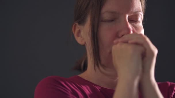 Женщина Молится Сжимая Руки Темной Комнате Ручная Съемка — стоковое видео