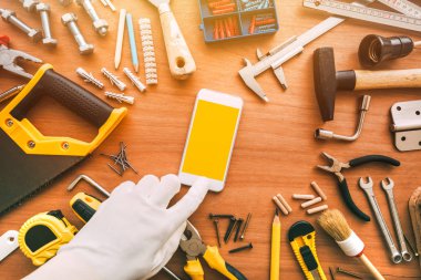 Flatlay handyman akıllı telefon uygulaması, tamirci cep telefonu tutan 