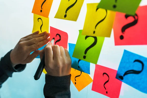 Mujer de negocios escribiendo signos de interrogación en la nota pegajosa colorido pap —  Fotos de Stock