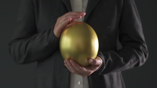 金の卵を持つビジネスウーマン 低いキー映像 — ストック動画