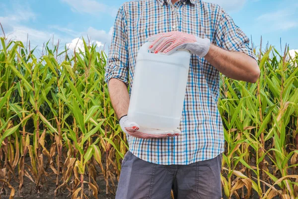 Landwirt hält unetikettierten Pestizidkrug auf Feld — Stockfoto