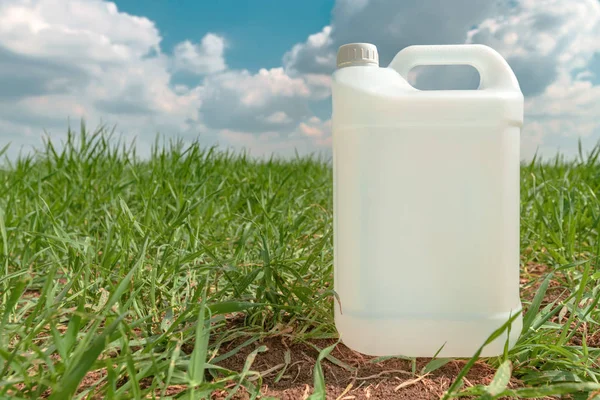 Contenedor de jarra de pesticida en blanco simulan en campo de hierba de trigo — Foto de Stock