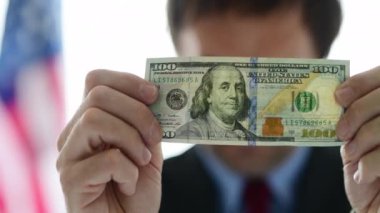 Amerikan işadamı yüz dolarlık banknot tutan, seçici odak, beyaz arka plan izole