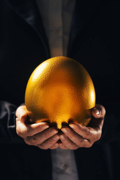 Successful businesswoman holding golden egg