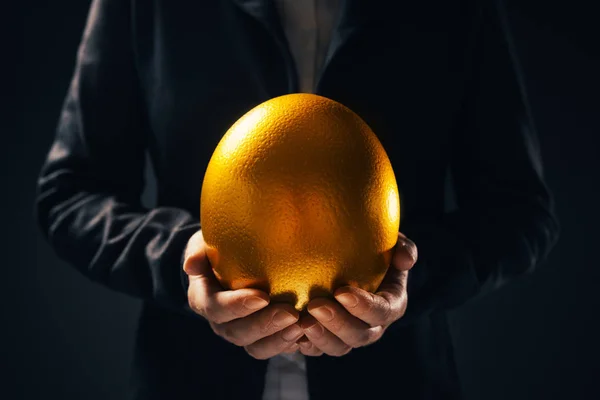 Successful businesswoman holding golden egg — Stock Photo, Image