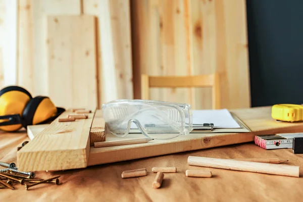 Protective goggles on carpentry woodwork workshop desk — Stock Photo, Image
