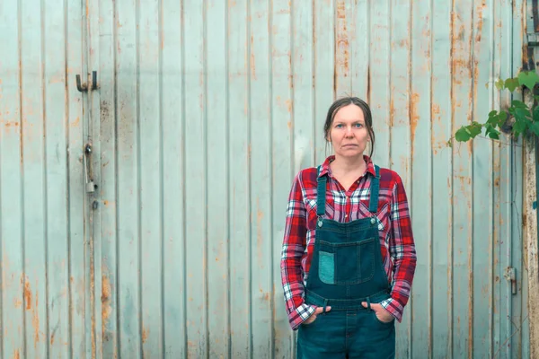 Portræt af smukke kvindelige landmand foran gård skur - Stock-foto