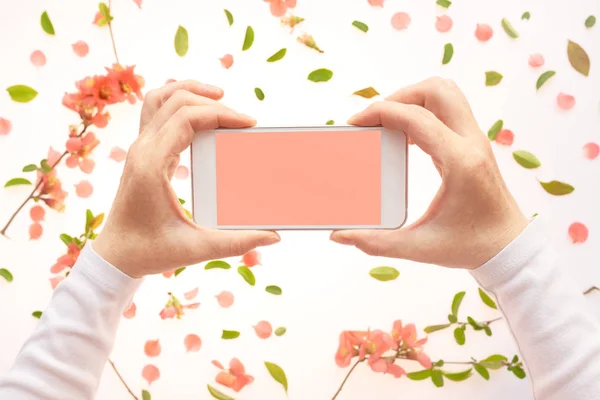 春の装飾で女性の手でスマートフォンのモックアップ — ストック写真