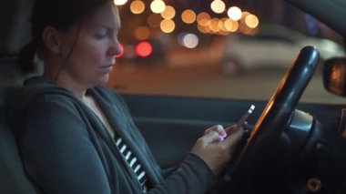 Gece arabada akıllı telefon kullanma, elinde cep telefonu ile kadın kişinin seçici odak düşük anahtar görüntü