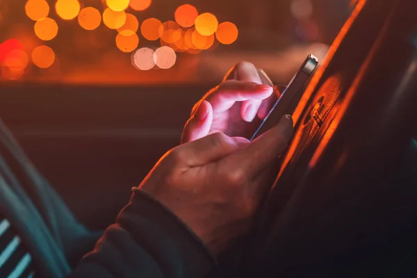 Uso del teléfono inteligente en el coche por la noche — Foto de Stock