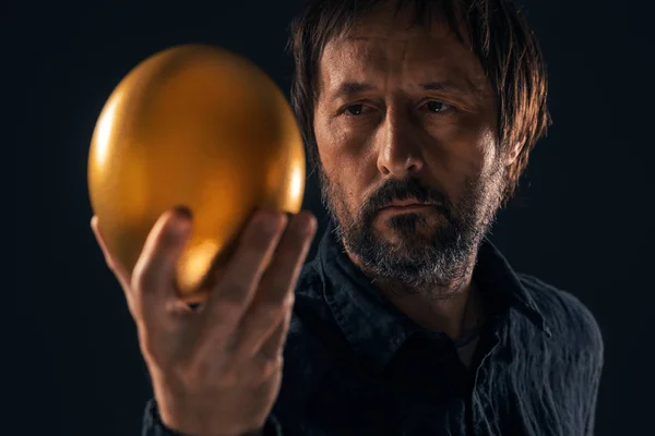 Людина і золоте яйце — стокове фото