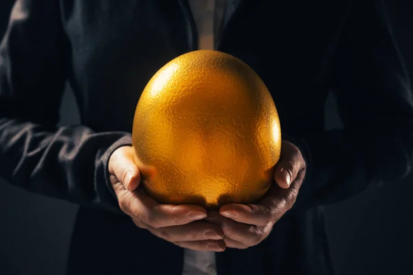 Successful businesswoman holding golden egg — Stock Photo, Image