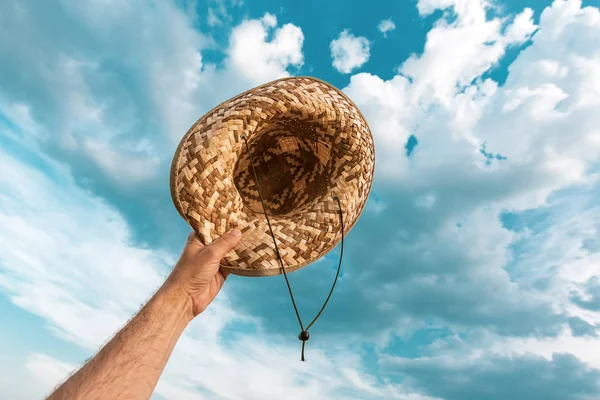 Alegre agricultor satisfeito segurando chapéu de palha ao ar livre — Fotografia de Stock