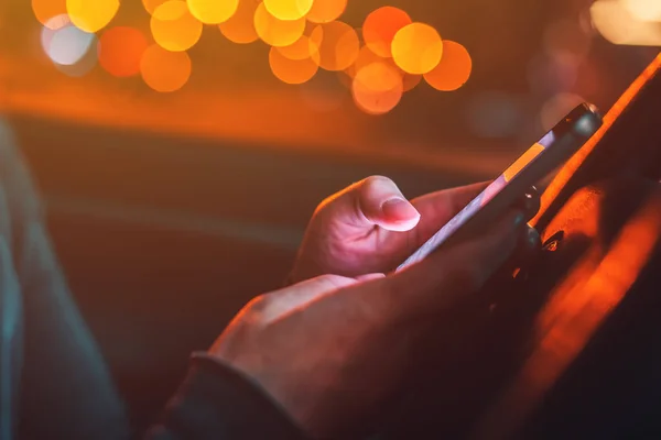 Uso del teléfono inteligente en el coche por la noche — Foto de Stock