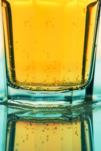 发泡的黄色软糖苏打水在玻璃杯里，近身喝 — 图库照片
