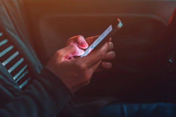 Mujer mensajes de texto en el teléfono móvil en el coche por la noche — Foto de Stock