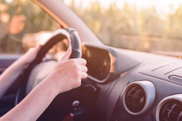 Conducir coche a través del campo, las manos femeninas en el volante — Foto de Stock