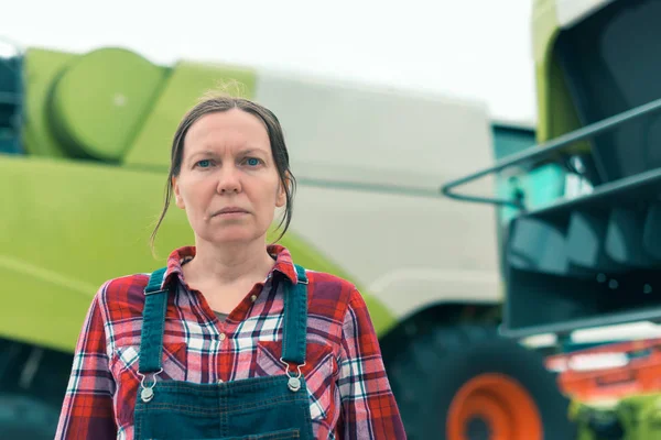 Female farmer posing in front of combine harvester — Stock Photo, Image