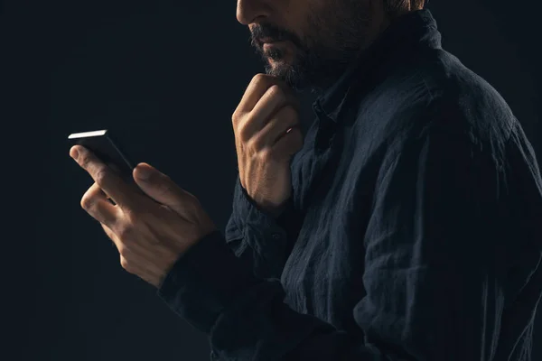 El hombre preocupado reflexivo está leyendo el mensaje de texto en el teléfono inteligente — Foto de Stock