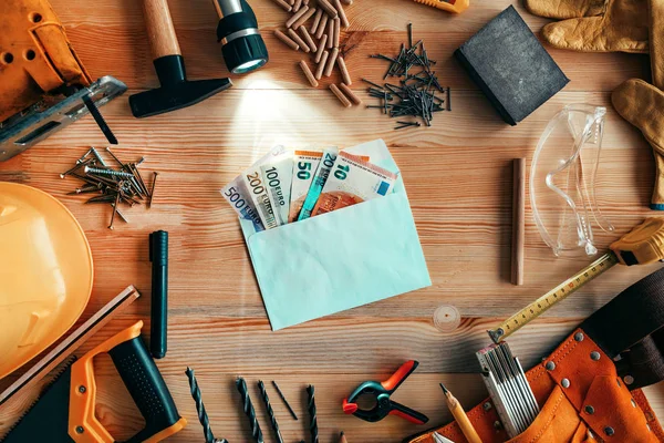 Dinero en sobres en el escritorio del taller de carpintería — Foto de Stock