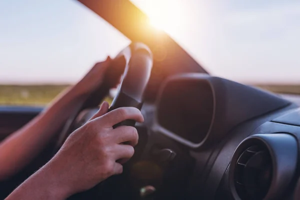 Driving car through countryside, female hands on steering wheel — Stock Photo, Image