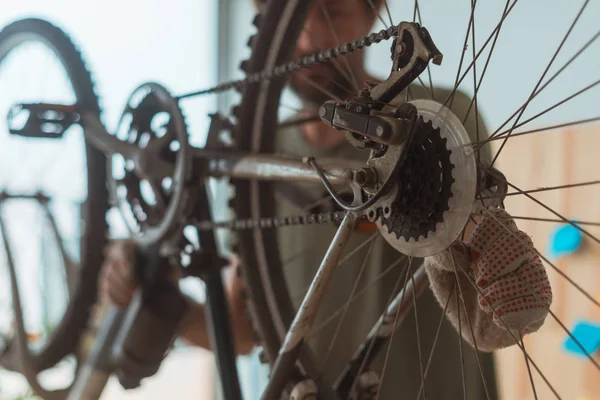 Mann repariert altes Mountainbike in Werkstatt — Stockfoto