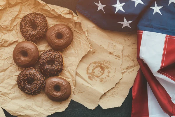 Donuts au chocolat doux et drapeau américain, vue de dessus — Photo