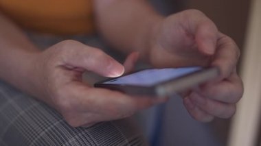 Akıllı telefon ekranında kadın başparmak kaydırma sayfası nın kapatılması, yetişkin beyaz kadın internete göz atmak için cep telefonu kullanarak