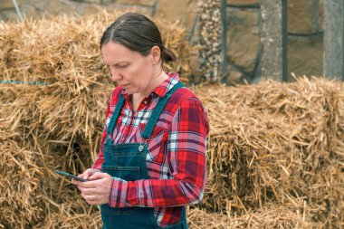 Kadın çiftçi cep telefonuna sms mesajı yazarak