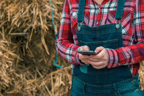 Kobieta rolnik wpisując wiadomość SMS na telefon komórkowy — Zdjęcie stockowe