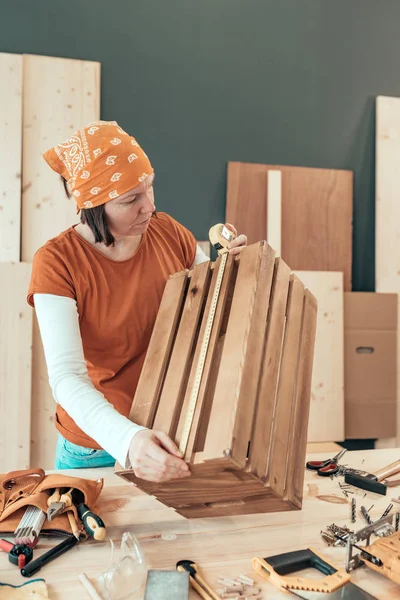 Kadın marangoz teyp ahşap sandık ölçme — Stok fotoğraf