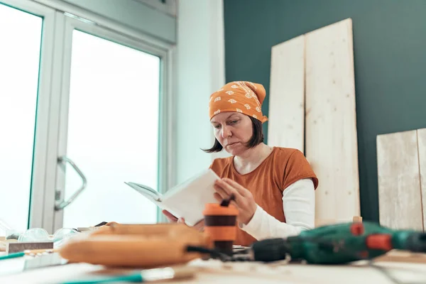 Cieśla kobiece czytanie projektu Diy instrukcja obsługi — Zdjęcie stockowe