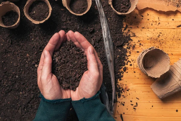 Gardener gazdaság talaj tölcséres kezében, felülnézet — Stock Fotó