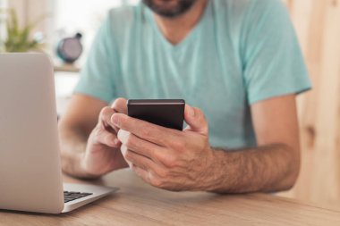 Ev ofisinde akıllı telefon kullanarak Freelancer