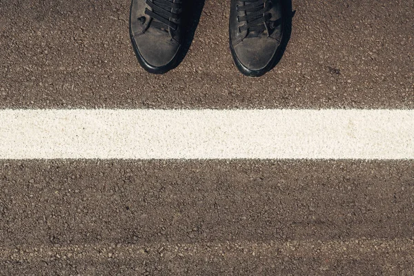 Explorateur urbain, homme aux chaussures modernes debout sur la route asphaltée — Photo