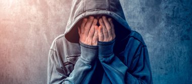 Desperate man in hooded jacket is crying clipart