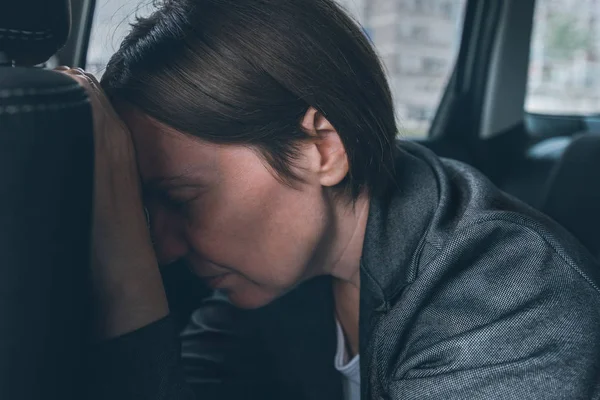 Tired businesswoman sleeping at car back seat — Stock Fotó