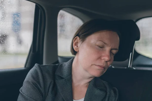 Trött affärskvinna sova på bil baksätet — Stockfoto