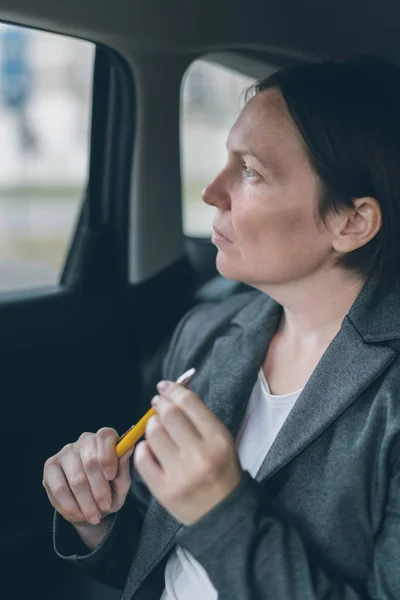 Mujer de negocios esperando en el asiento trasero del coche — Foto de Stock