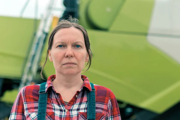 Vrouwelijke boer poseren voor de maaidorser — Stockfoto