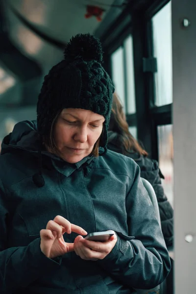 Mulher mensagens de texto no telefone celular em ônibus público no inverno — Fotografia de Stock