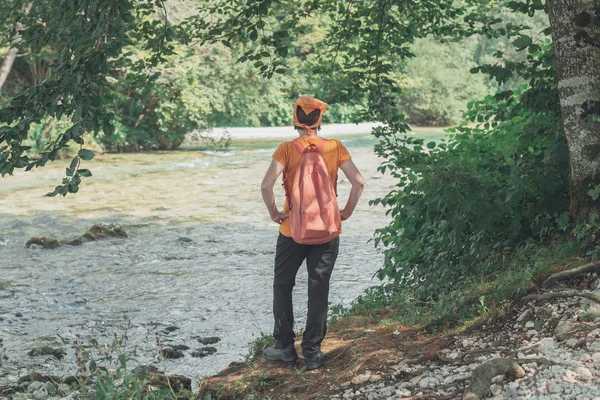 Rückansicht einer Wanderin mit Blick auf den Gebirgsfluss — Stockfoto