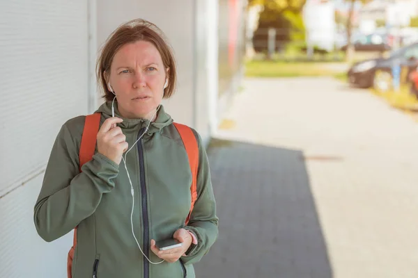 Female jogger talking on mobile phone handsfree — Stock Photo, Image