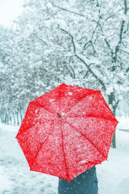 Kış karda yürüme kırmızı şemsiye altında kadın