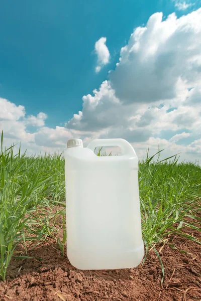 小麦グラス畑でモックアップ空白の農薬ジャグコンテナ — ストック写真