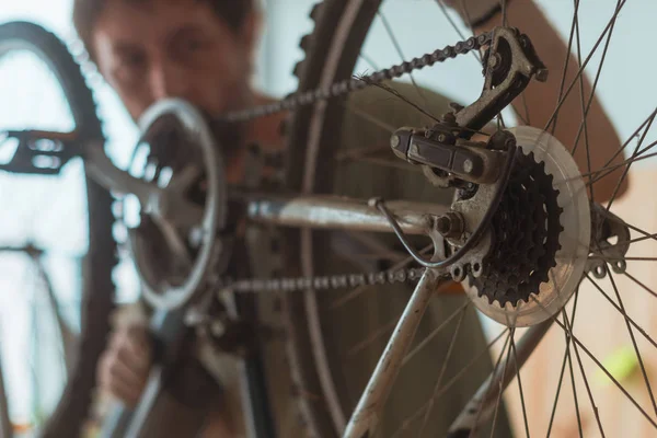 Bicycle mechanic repairing old mountain bike in workshop