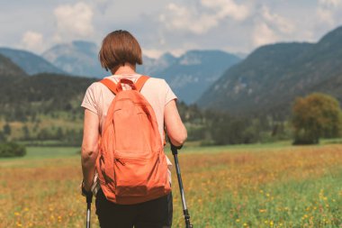 Kadın yürüyüşçü otobanda Alp kırsalında yürüyüş yapıyor.